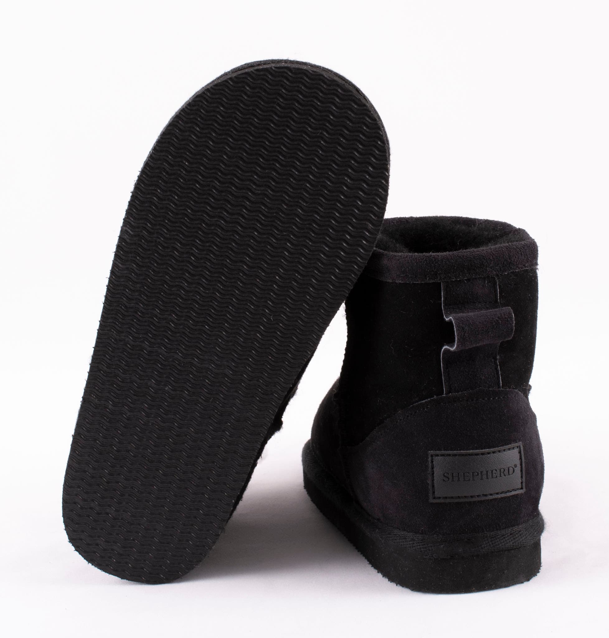 A pair of black ankel high sheepskin boots with a warm and comfortable sheepskin inside.