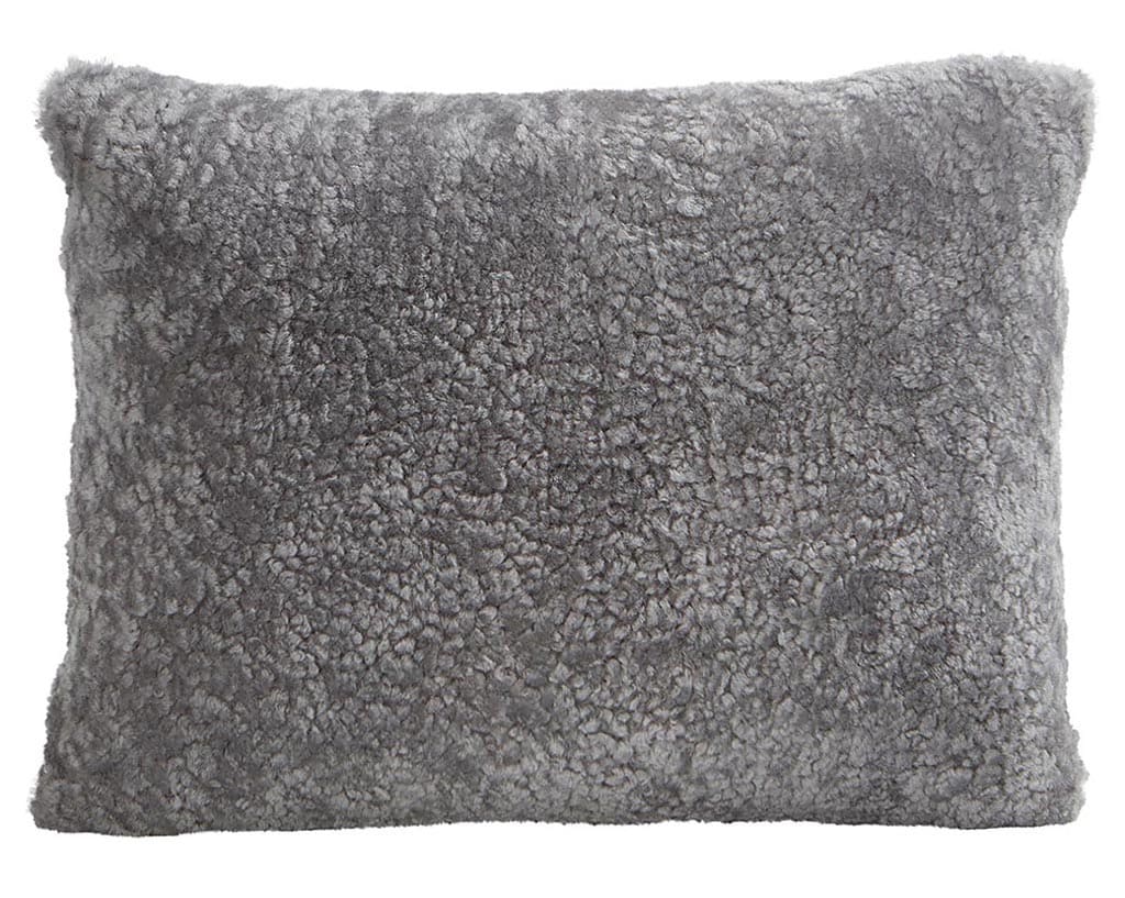 En kudde med framsida i korthårig mjuk fårskinn med sitt ursprung ifrån Australien och baksida i vävd ull med måtten 40x30cm