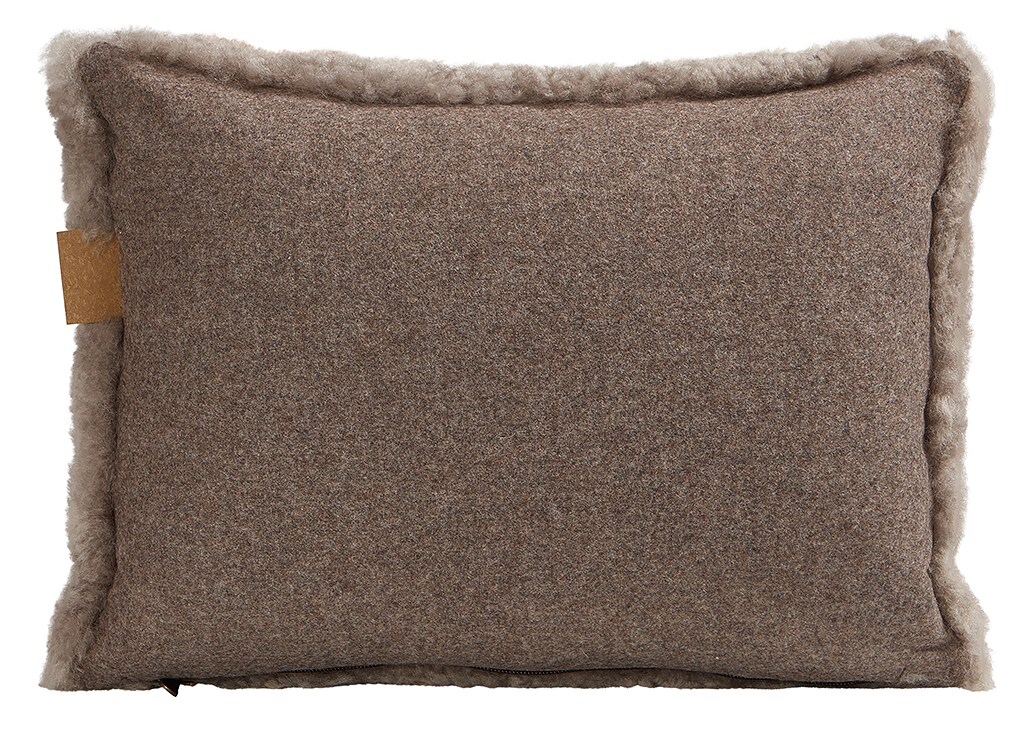 En kudde med framsida i korthårig mjuk fårskinn med sitt ursprung ifrån Australien och baksida i vävd ull med måtten 40x30cm