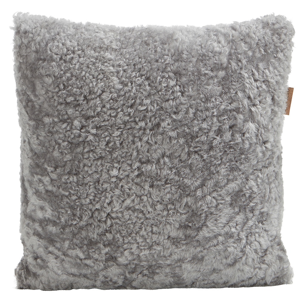 En kudde med framsida i korthårig mjuk fårskinn med sitt ursprung ifrån Australien och baksida i vävd ull med måtten 40x40cm