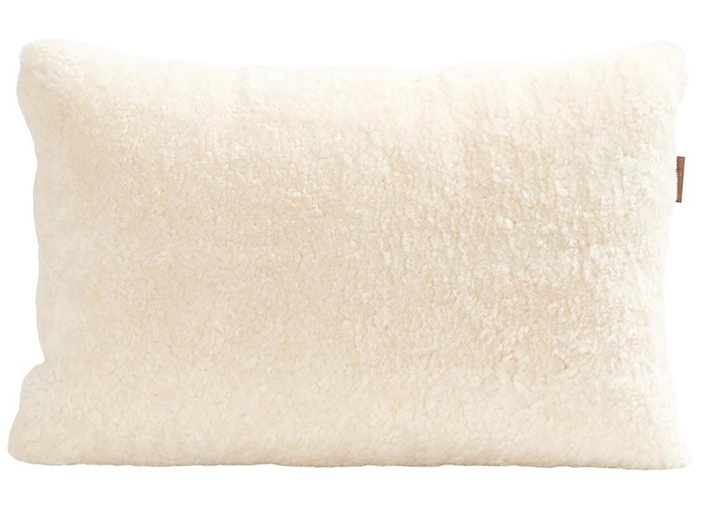 En kudde med framsida i korthårig mjuk fårskinn med sitt ursprung ifrån Australien och baksida i vävd ull med måtten 60x40cm