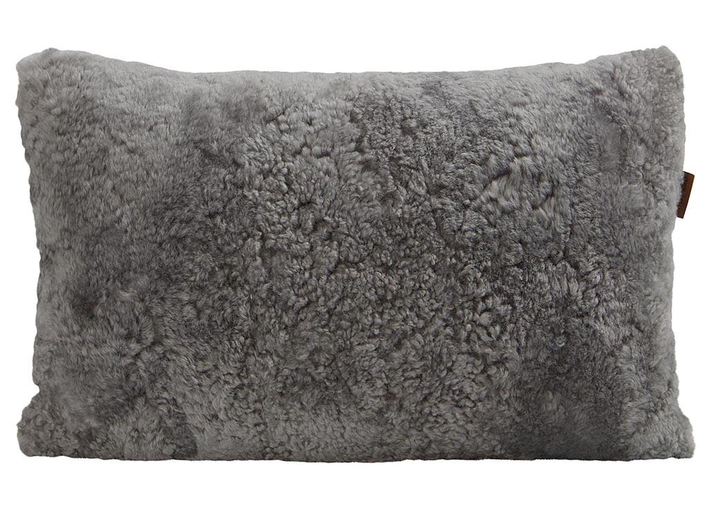 En kudde med framsida i korthårig mjuk fårskinn med sitt ursprung ifrån Australien och baksida i vävd ull med måtten 60x40cm