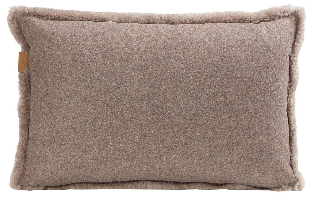 En kudde med framsida i korthårig mjuk fårskinn med sitt ursprung ifrån Australien och baksida i vävd ull med måtten 60x40cm