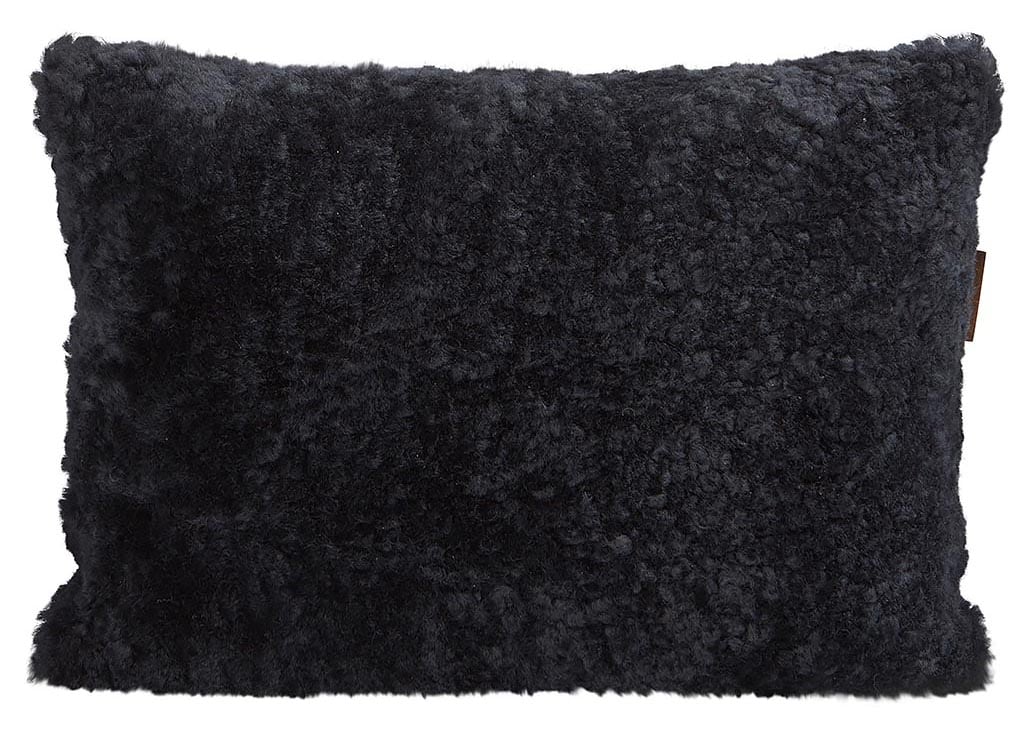 En kudde med framsida i korthårig mjuk fårskinn med sitt ursprung ifrån Australien och baksida i vävd ull med måtten 60x40cm
